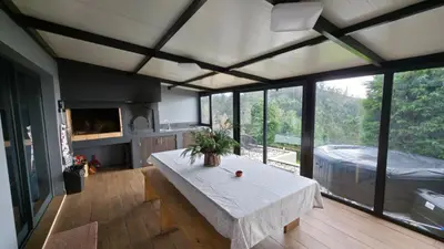 a living room with a table in a room with windows at Casa Vicente in Arco da Calheta
