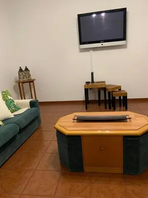 a living room with a couch and a flat screen tv at Porto Santo Island Ocean Apartment in Vila Baleira