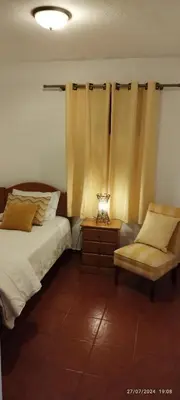 a bedroom with a bed and a chair and a lamp at Porto Santo Island Ocean Apartment in Vila Baleira