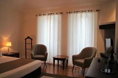 a hotel room with a bed and two chairs and a table at Guest house Santa Maria in Funchal