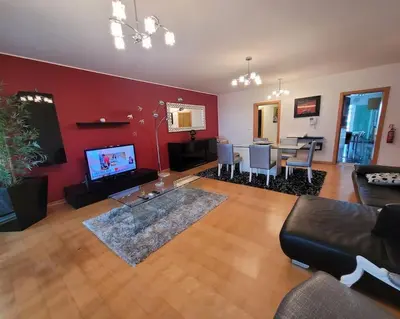 a living room with a couch and a dining room at Nova Madeira Apartment Machico in Machico