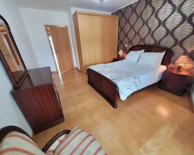 a bedroom with a large bed and a couch at Nova Madeira Apartment Machico in Machico