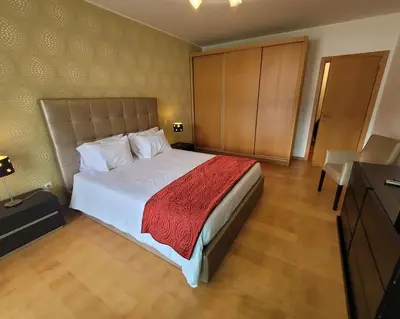 a bedroom with a large bed with a red blanket at Nova Madeira Apartment Machico in Machico