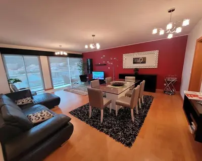 a living room with a table and a dining room at Nova Madeira Apartment Machico in Machico