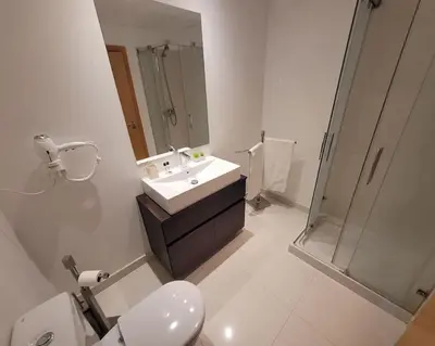 a bathroom with a toilet and a sink and a shower at Nova Madeira Apartment Machico in Machico