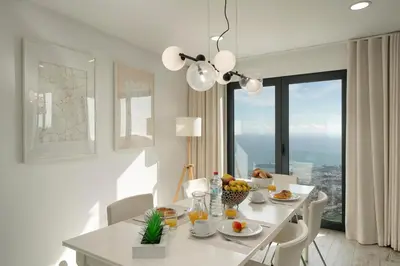 a white dining room with a table and a window at OurMadeira - Monte White House in Funchal