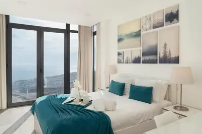 a bedroom with a white bed and a large window at OurMadeira - Monte White House in Funchal