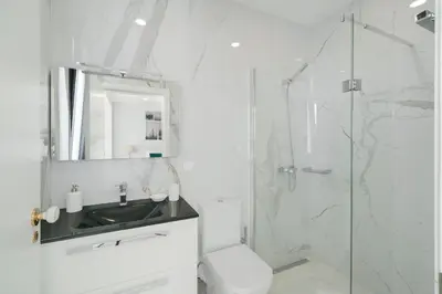 a white bathroom with a sink and a shower at OurMadeira - Monte White House in Funchal