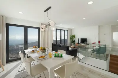 a dining room and living room with a white table and chairs at OurMadeira - Monte White House in Funchal