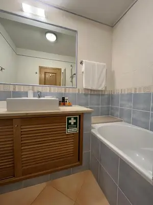 a bathroom with a tub and a sink and a mirror at Margarida Apartment in Luz