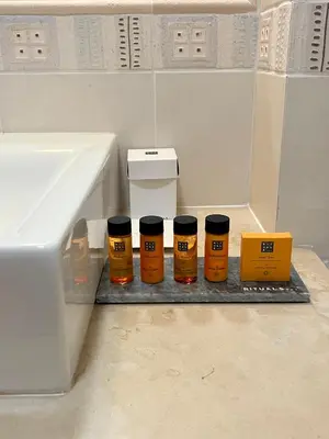 three bottles of honey sitting on a shelf next to a sink at Margarida Apartment in Luz