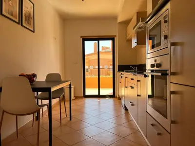 a kitchen with a table and a dining room at Margarida Apartment in Luz