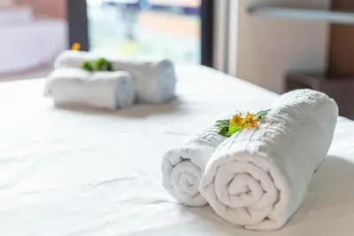 a stack of towels sitting on top of a bed at Madeira Four Seasons in Funchal