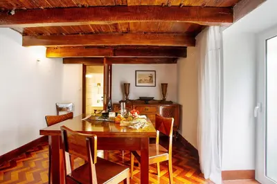 a kitchen with wooden cabinets and a table with chairs at Mother's House in Calheta