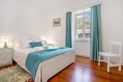 a bedroom with a bed and a chair and a window at Mother's House in Calheta