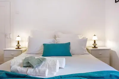 a white bed with towels and pillows on it at Mother's House in Calheta