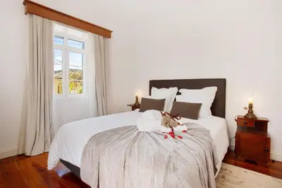 a dog sitting on a bed in a bedroom at Mother's House in Calheta
