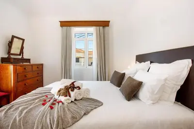 a bedroom with a bed with white sheets and pillows at Mother's House in Calheta