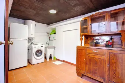 a kitchen with a refrigerator and a washing machine at Mother's House in Calheta