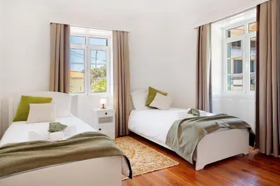 two twin beds in a room with a window at Mother's House in Calheta