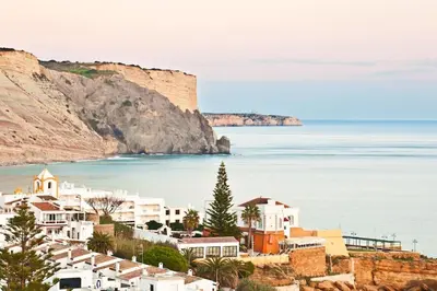 a group of buildings on a hill next to the ocean at Casa Vista da Praia in Luz