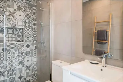 a bathroom with a sink and a shower with a mirror at Casa Vista da Praia in Luz