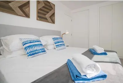 a white bed with blue and white towels on it at Casa Vista da Praia in Luz