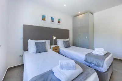 two beds in a room with white walls at Casa de Férias, Luz in Luz