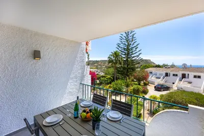a balcony with a table and a view of a yard at Casa de Férias, Luz in Luz