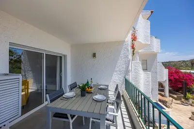 a patio with a table and chairs on a balcony at Casa de Férias, Luz in Luz