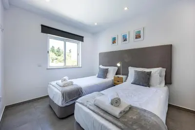 a bedroom with two beds and a window at Casa de Férias, Luz in Luz