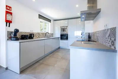 a kitchen with white cabinets and a counter top at Casa de Férias, Luz in Luz