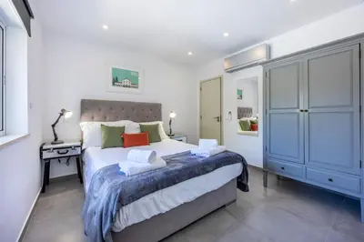 a bedroom with a large bed and a blue cabinet at Casa de Férias, Luz in Luz