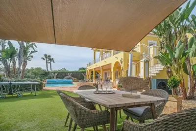 an outdoor patio with a wooden table and chairs at Vivenda Kristina in Luz