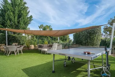 a ping pong table in a garden with a canopy at Vivenda Kristina in Luz