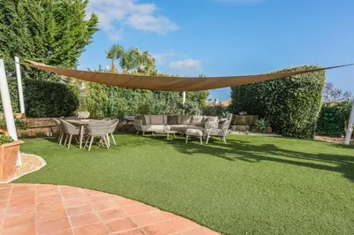 a backyard with a lawn with a table and chairs at Vivenda Kristina in Luz