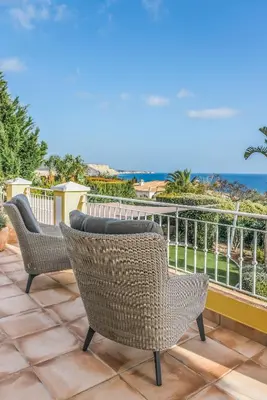 a patio with two chairs and a view of the ocean at Vivenda Kristina in Luz