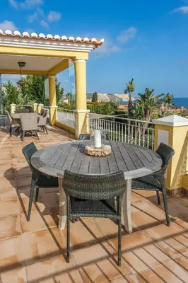 a wooden table and chairs on a deck at Vivenda Kristina in Luz