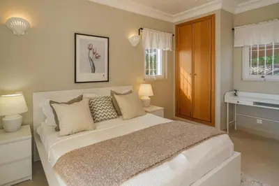 a bedroom with a large bed and a sink at Vivenda Kristina in Luz