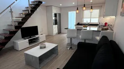a living room with a couch and a tv and a kitchen at VCS House by Madeira Holiday in Funchal