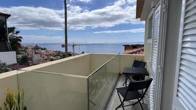a balcony with two chairs and a view of the ocean at VCS House by Madeira Holiday in Funchal