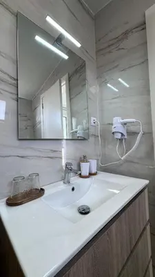a bathroom with a white sink and a mirror at VCS House by Madeira Holiday in Funchal