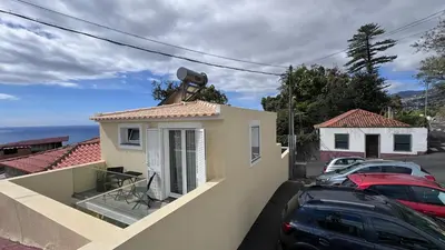 a house with cars parked in a parking lot at VCS House by Madeira Holiday in Funchal