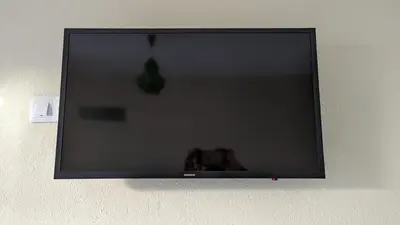 a flat screen tv hanging on a wall at Banana Tree House in Ponta do Sol