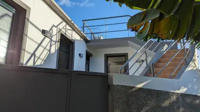 a house with a fence and stairs on it at Banana Tree House in Ponta do Sol