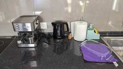 a kitchen counter with a coffee maker and a purple bag at Banana Tree House in Ponta do Sol