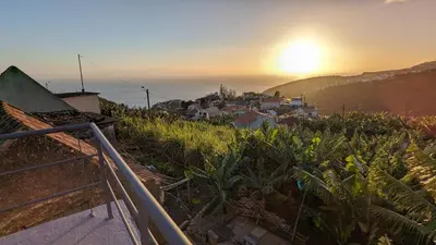 a view of a sunset from a house on a hill at Banana Tree House in Ponta do Sol
