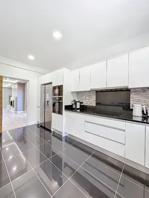 a kitchen with white cabinets and a tile floor at Villa Faísca in São Roque do Faial