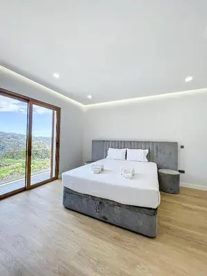 a bedroom with a large bed and a large window at Villa Faísca in São Roque do Faial
