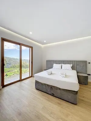 a bedroom with a large bed and a large window at Villa Faísca in São Roque do Faial